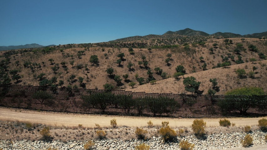 Aerial view of Nogales border area showing border fence separating the United States of America and Mexico with U.S. Border and Customs Protection patrolling border area with their vehicles