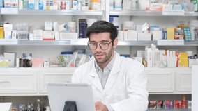 Middle eastern male pharmacist sits with customer and discusses choice of medication viewing from live steaming with digital tablet, online counseling, video call, medical technology, New Normal 
