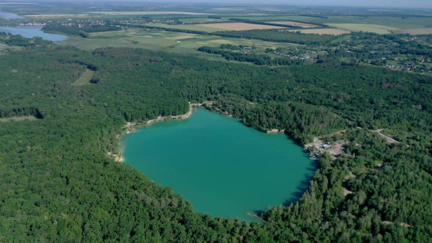 Beautiful blue-green lake in the middle of the forest. Water color of a sea wave. Beautiful scenery from a bird