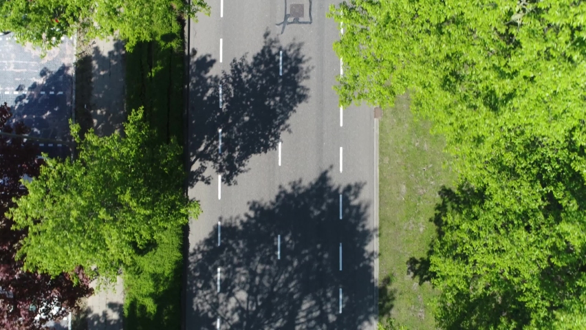 Aerial top down view of grey station wagon vehicle overtaking drone camera driving over straight road testing area for development of self driving electronic automobiles ev's 4k high resolution Royalty-Free Stock Footage #1067839256