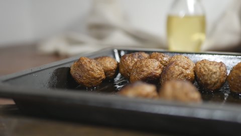 fried meatballs in a metal baking sheet on the table. Close-up. Filming Dolly.
