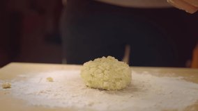 A woman prepares dessert in the kitchen. He makes cheesecakes out of a mixture of cottage cheese. The video shows the process of cooking at home.
