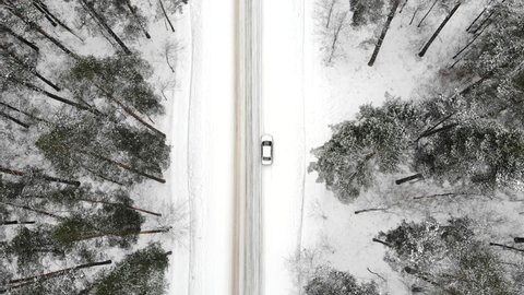 Car on a winter road in the forest, top view