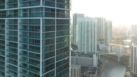 Contemporary urban cityscape view, drone b roll footage. Cinematic glass and concrete design apartment buildings at the river channel, 4K. Modern downtown Miami architecture, aerial at sunset