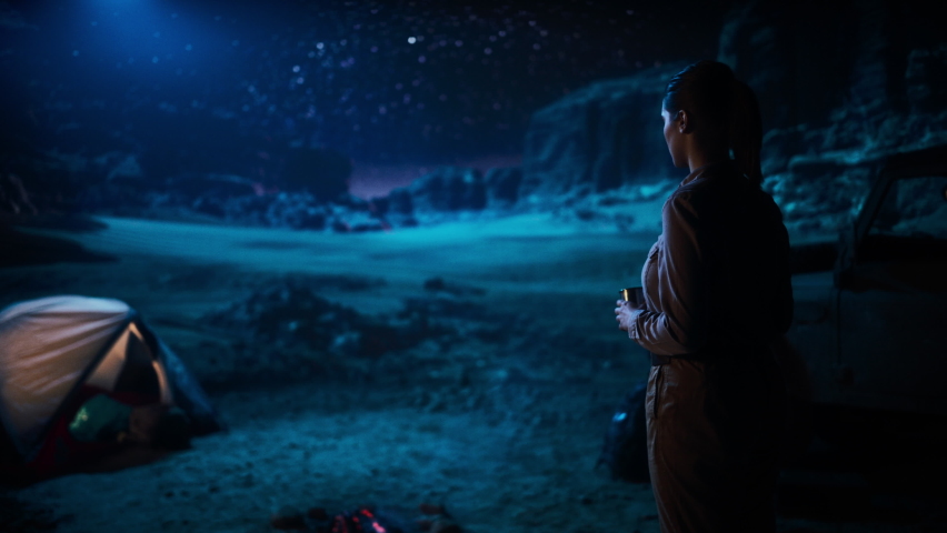 Happy Couple Camping in the Canyon at Night, Standing by Campfire, Holding Hands Lovingly and Romantically Watching Star Sky. Two Traveling people on a Nature Inspirational Vacation Trip, Journey