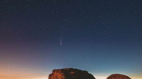 Comet Neowise C 2020 F3 In Night Starry Sky Above Haystacks In Summer Agricultural Field. Night Stars Above Rural Landscape With Hay Bales After Harvest. Agricultural Concept. 4K Timelapse. Arkistovideo