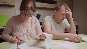 A married couple in the evening sitting at the table looks through the checks - Powered by Shutterstock - Get 15% off with code: PIKWIZARD15