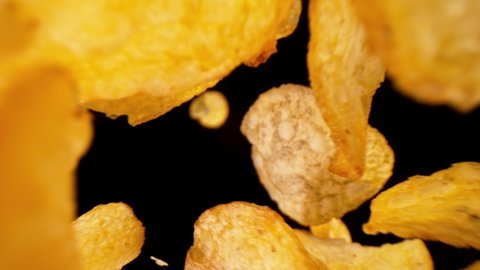 Super Slow Motion Shot of Potatoes Chips Falling on Black Background, 1000fps.