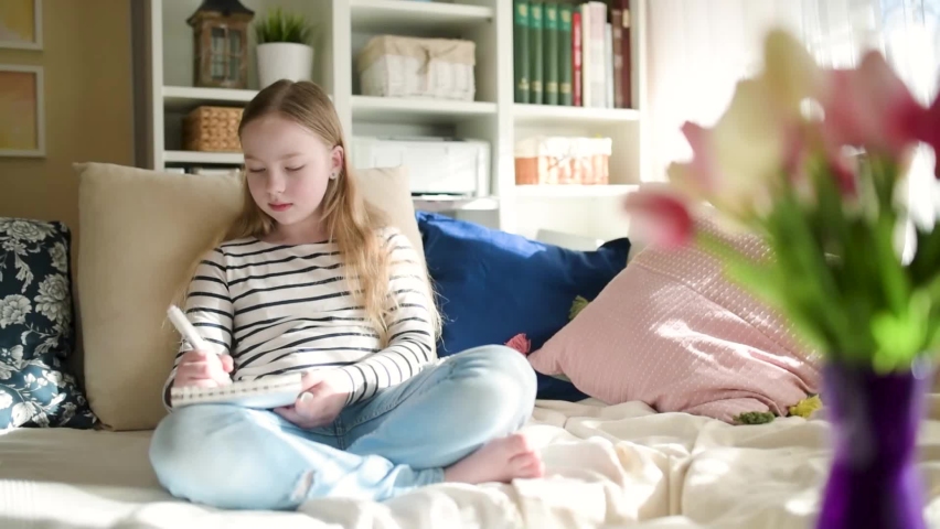 Cute young girl writing letter at home. Child doing her homework in her room. Education for kids