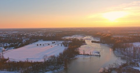 American town on after snowfall USA aerial view of winter sunset scenery time in suburb city with snow covered of residential quarters by the river.