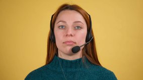 Young woman in headset with microphone over yellow background isolated