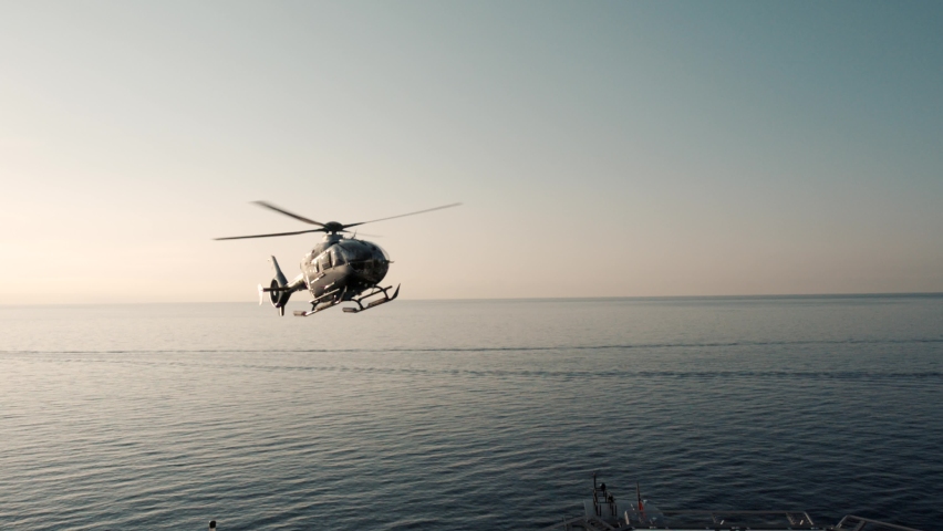Jet helicopter landing on large super yacht heli deck at sea. Filmed in 200fps for excellent cinematic slow motion. Royalty-Free Stock Footage #1067892536