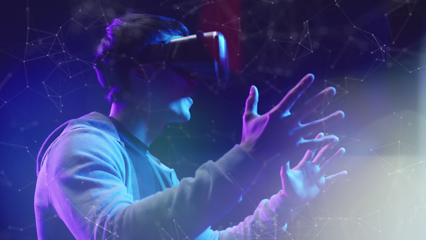 Teenager having fun play VR virtual reality glasses Metaverse sport game 3D cyber space futuristic neon colorful background, future digital technology game and entertainment | Shutterstock HD Video #1067906534