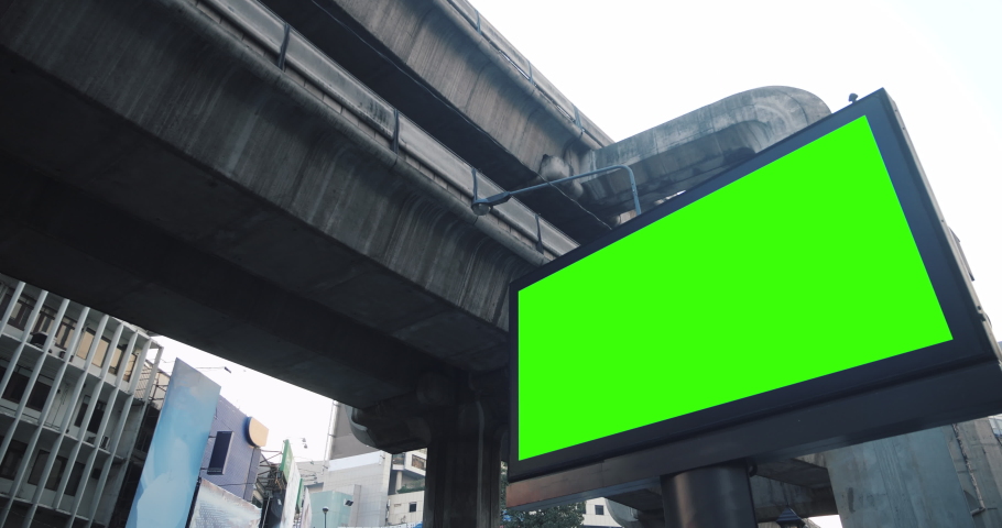 Empty modern billboard with a green screen for advertising with sky train moving forward in station, blank billboard on Electric train station in cyberpunk urban city. Royalty-Free Stock Footage #1067912525
