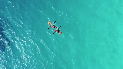 Kayaking in Nature National Park. Tropical Landscape. Camera Zoom Out and Hovering Above Two people in Canoe Surrounded Indian Ocean. Dolphin Swims near the boat. Aerial view.: stockvideo