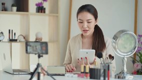 Young asian beauty blogger present cosmetics makeup broadcast live online video vlog.
