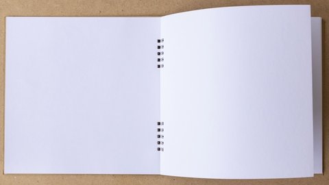4k-Stop motion book animation open white blank page for writing on wooden background.