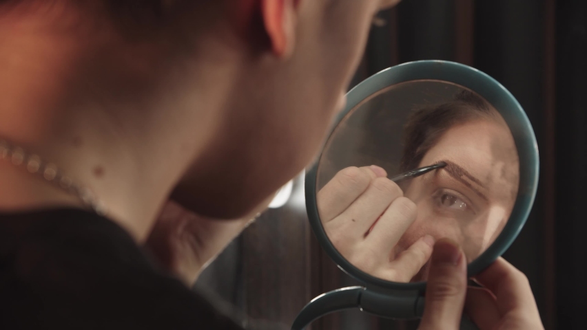 Drag artist - young man drawing new eyebrows in front of the small mirror Royalty-Free Stock Footage #1067932346