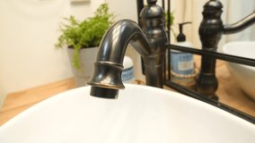 Close up shot of an oil rubbed copper faucet. Extreme close up video of a vintage style copper faucet.