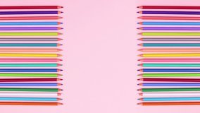 Colorful colored wooden pencils on pink theme. Drawing stationery stop motion