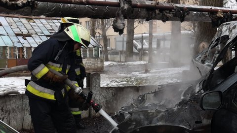 DNIPRO, UKRAINE - February 22, 2021. Rescuers extinguish a burnt-out car