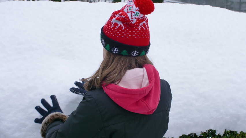 young girl is happily to play with the snow