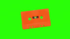 A Stop motion video of a cassette tape moving and dancing around against green screen background