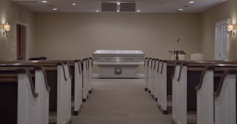 Funeral with casket in empty church chapel with no people due to covid pandemic.