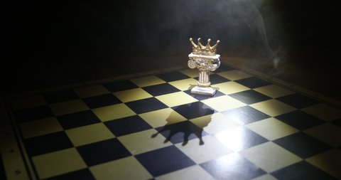 Beautiful crown miniature on chessboard. chess board game concept of business ideas and competition and strategy ideas concept. Chess figures on a dark background with smoke and fog. Selective focus