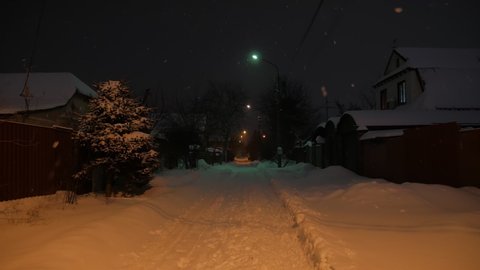 Snow on empty night street one car rides