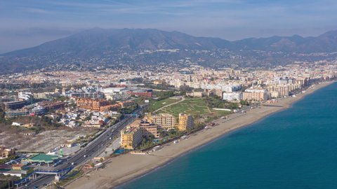 Aerial drone hyperlapse timelapse of Fuengirola in Spain and the beachfront from over the sea looking back