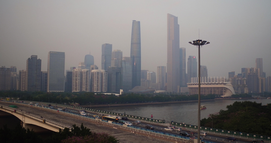 View of Guangzhou central buildings district and Guangzhou bridge over pearl river with heavy traffic in the afternoon. Aerial shot. Guangdong, China.