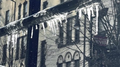 NYC, USA - FEB 21, 2021: icicles hanging from metal pole snowing on 8th Street in Greenwich Village in winter in New York City.