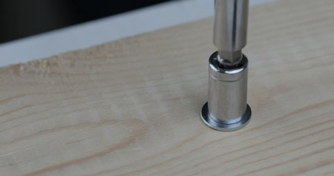 Close up tightens nut with a screwdriver.