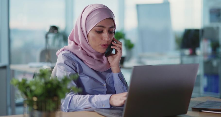Arabic young formal businesswoman talking business talk in corporate office working in call center using laptop computer. | Shutterstock HD Video #1067969738