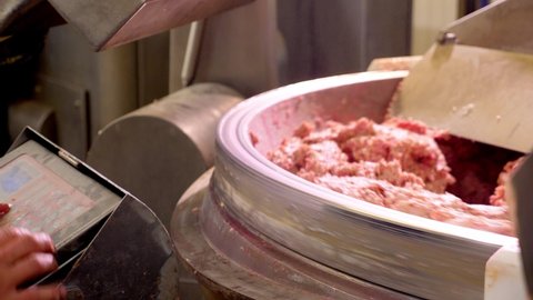 Processing lard or meat in minced meat on a huge meat grinder at a meat factory closeup.