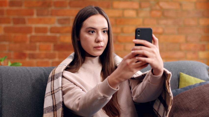 Face recognition app. Young woman making selfie on smartphone for unlock and typing message or e-mail, sitting at home, slow motion Royalty-Free Stock Footage #1067985482