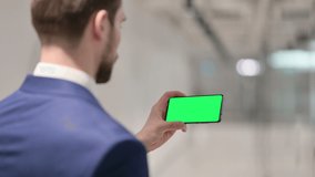 Businessman Watching Smartphone with Green Chroma Key Screen 