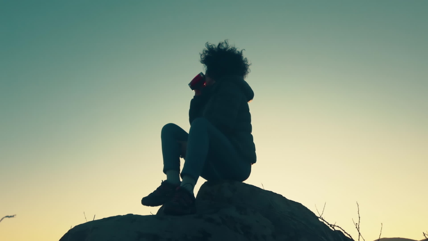 Discovery Travel Destination Concept. Hiker Woman Drink Cafe To The Mountain Top Against Backdrop Of Sunset Sun Shining