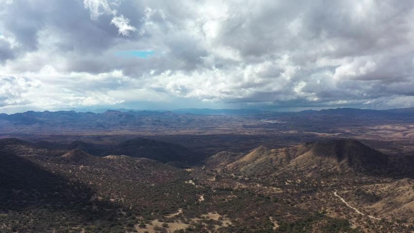 The borderlands between Arizona and Mexico as seen from the U.S. side in the Coronado National Forest east of Nogales, AZ. The border wall and Nogales, Mexico are seen in the distance. Aerial shot.