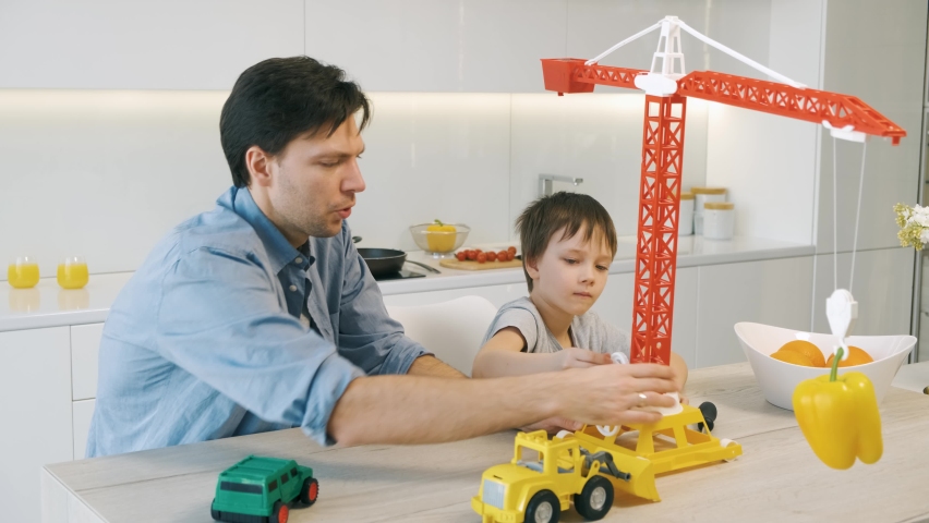 Father and son playing with toys in the kitchen