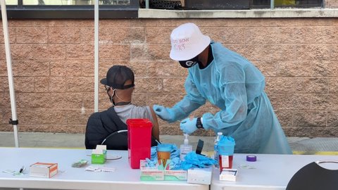 Homeless persons receive COVID-19 vaccines from nurses at a vaccination clinic set up in the parking lot of the L.A. Mission in Los Angeles, Wednesday, Feb. 24, 2021. 