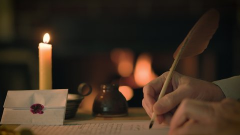 A cozy 1800s scene lit by the warm glow from an out of focus fireplace in the background of a man writing a letter using a quill pen.