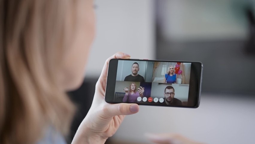 A woman talks with her friends via video link. A modern video messenger on a smartphone for everyone. | Shutterstock HD Video #1068028385