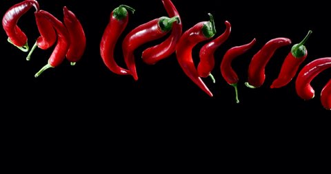 Red chili peppers slowly fly up and fall on a black background. Blackmagic Ursa Pro G2, 300 fps.