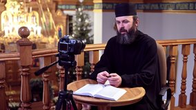 An Orthodox priest is recording a video for his blog. Preaching during a pandemic.