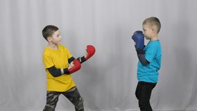Athletes in a yellow and blue T-shirt and multi-colored pads on their arms practice punches on pads