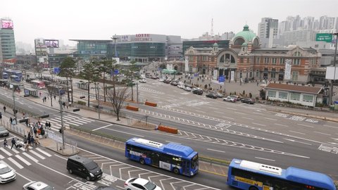 SEOUL, SOUTH KOREA - APRIL 01, 2018: Bus transfer center, new and Old Seoul Station buildings. People walk at pedestrian crossing, many roads split on lanes at modern outdoor coach terminal
