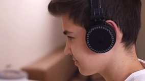 Close up of young teenage boy in wireless headphones speak with friends while play game