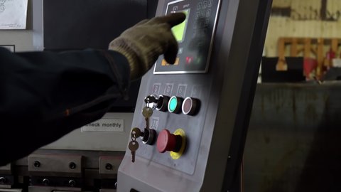 Factory Worker in Dirty Gloves Press Buttons on Remote Control from automated machine. Modern plant. Industrial line. Metal Construction Production. Manufacturing line. Processing line. Close up. 4k